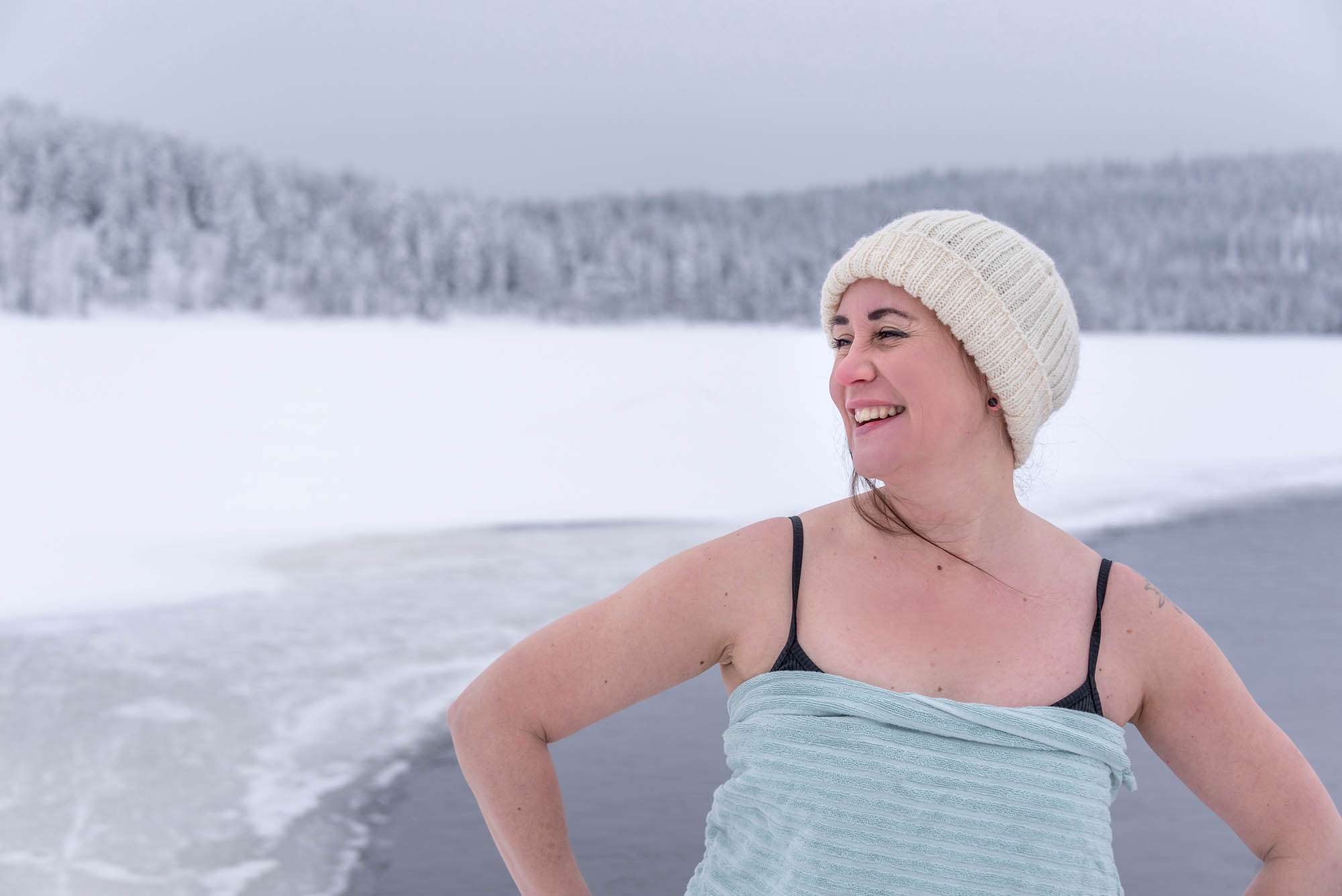 Woman ice swimming in winter in Lapland, Finland.